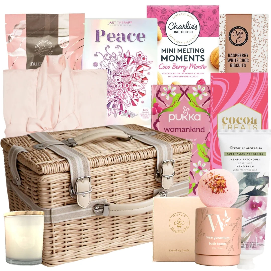 Gift basket with wicker hamper, candles, and various products including a book titled 'Peace'.