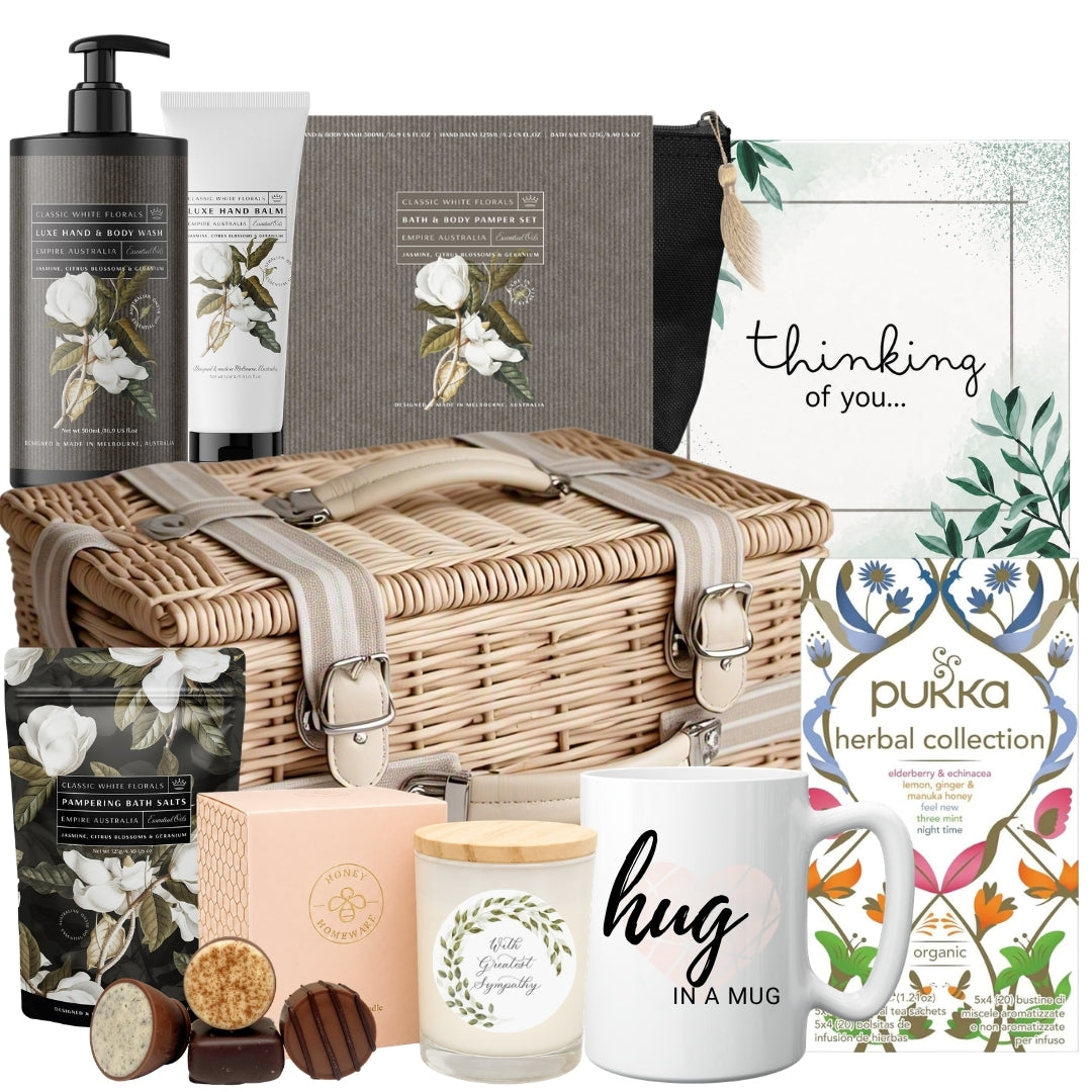 Sympathy gift basket for her featuring herbal tea, a hug mug, bath and body pamper set, chocolates, and a soothing soy candle
