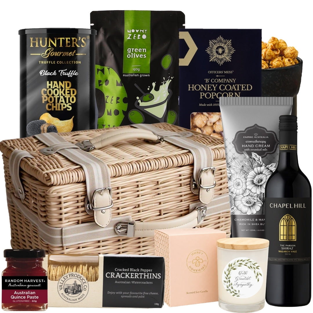 Sympathy gift basket featuring Shiraz, gourmet snacks, olives, hand cream, and a soothing soy candle