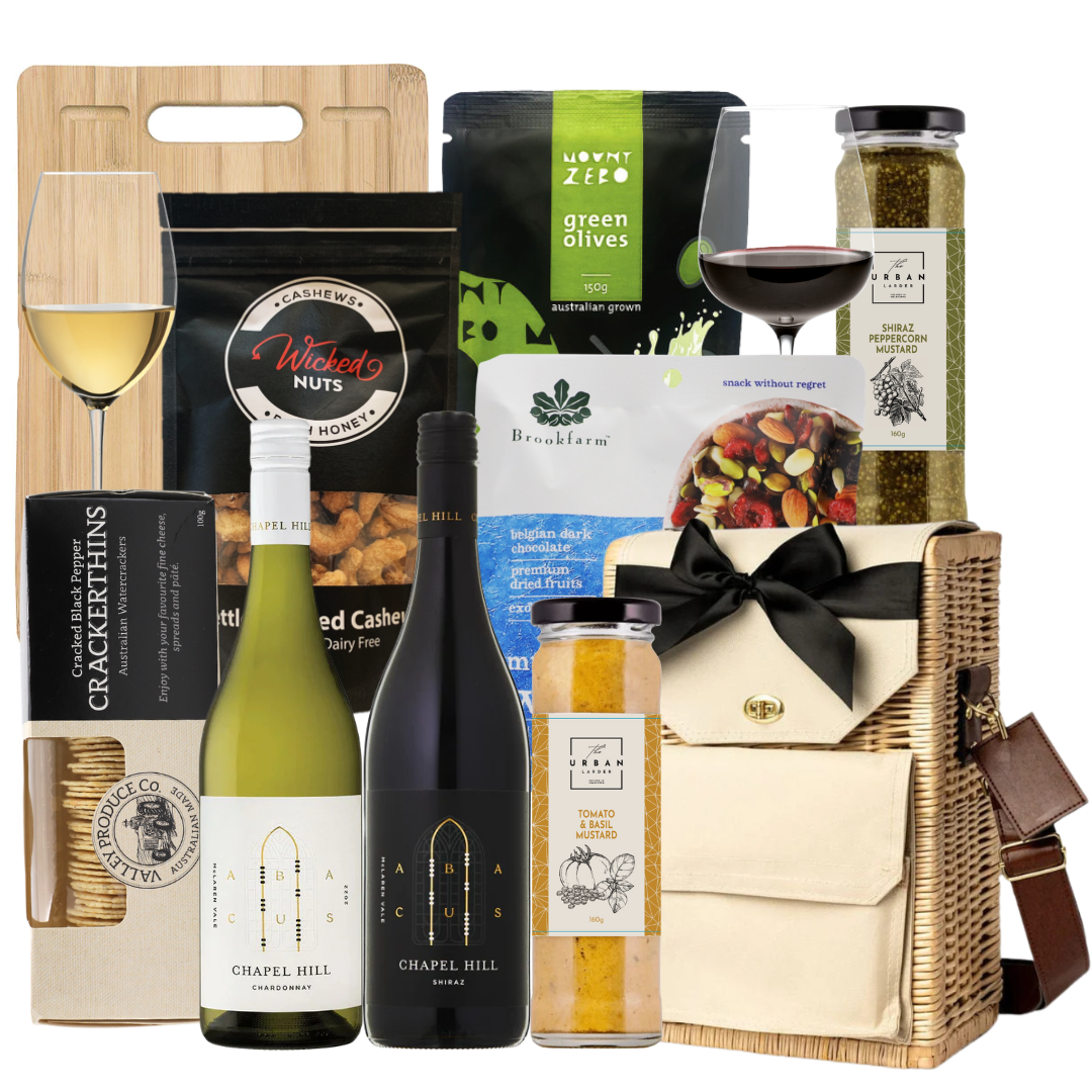 Gourmet gift basket with wine, snacks, and other items on a white background