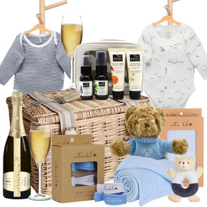 Baby gift basket with clothes, bottles, and teddy bear on a white background