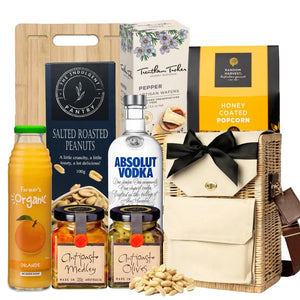 Gift basket with Absolut Vodka, snacks, and other items on a white background