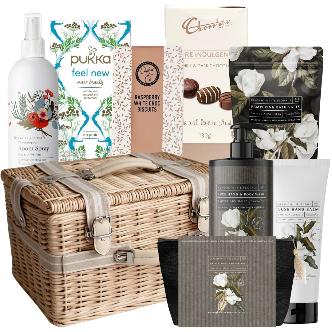 Gift basket with various products including a wicker basket, bottles, and boxes on a white background.