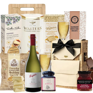 Gourmet gift basket with wine, snacks, and other treats on a white background