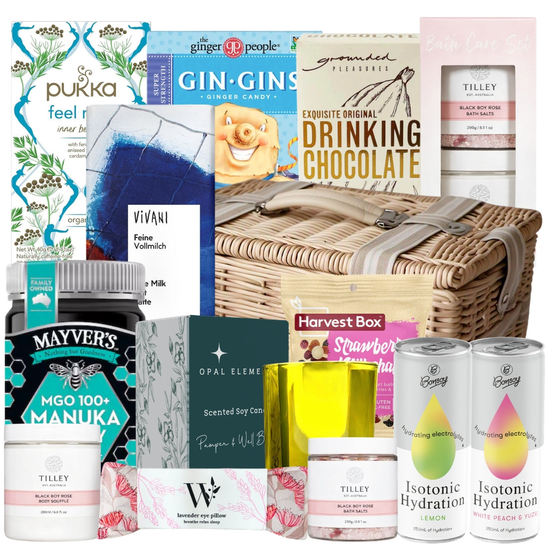 Best get well gift basket featuring Manuka honey, electrolyte drinks, herbal tea, a lavender eye pillow, bath care set, chocolates, and a soy candle