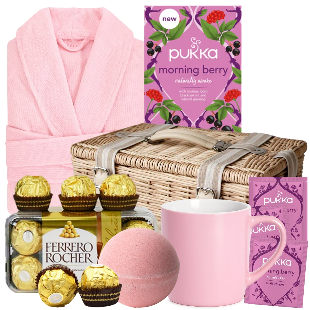 Get well gift basket for her featuring a blush pink robe, herbal tea, bath bomb, Ferrero Rocher chocolates, and a pink mug