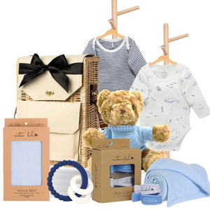 Baby boy gift hamper featuring Pure Baby bodysuits, a teddy bear, muslin wrap, pram clips, and a blue teether